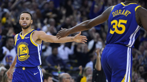 Steph Curry high-fives Kevin Durrant after Curry's 3-point shot against the Cleveland Cavaliers.