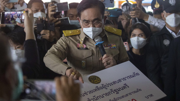 Thai Prime Minister Prayut Chan-o-cha presents replica compensation cheques to family members of victims.