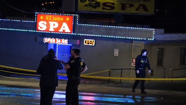 Law enforcement officials confer outside a massage parlour following a shooting in Atlanta.