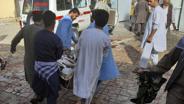 People carry the body of a bombing victim in Kunduz province, northern Afghanistan. 