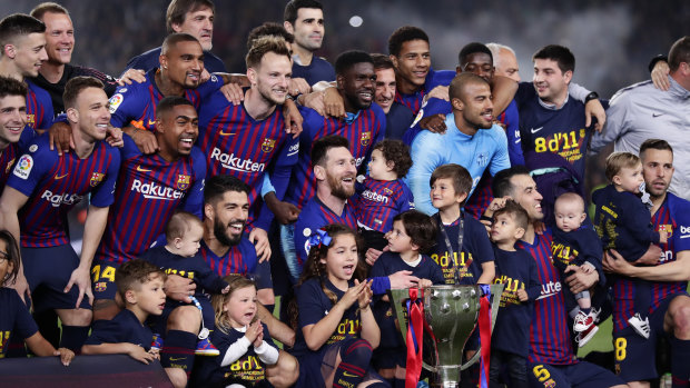 Barca players celebrate with the trophy.
