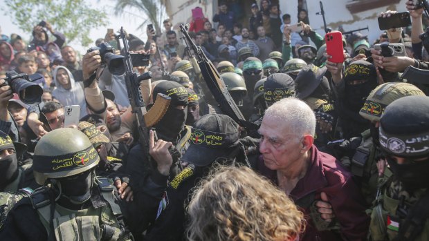 Gadi Moses, 80, centre right,  is escorted by Hamas and Islamic Jihad fighters.