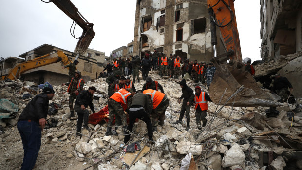 Civil defence workers and security forces search through the wreckage of collapsed buildings, in Hama, Syria.