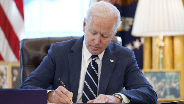 US President Joe Biden signs the American Rescue Plan, a coronavirus relief package, in the Oval Office of the White House.