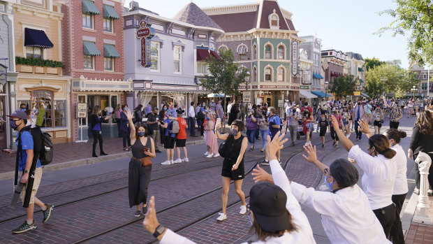 Guests are greeted by staff, right, down Main Street USA at Disneyland.