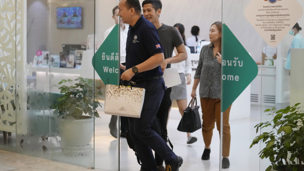 A staff member, left, from the British embassy arrives at Samitivej Hospital in Bangkok, Thailand.