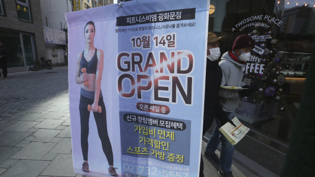 Keep the beats down: An ad of a fitness center opening sits on a street corner in Seoul, South Korea.