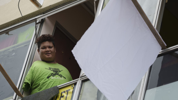 Mohamad Nor Abdullah, born without arms, put a white flag outside his rented room in Kuala Lumpur, Malaysia, to signal for help during the lockdown.