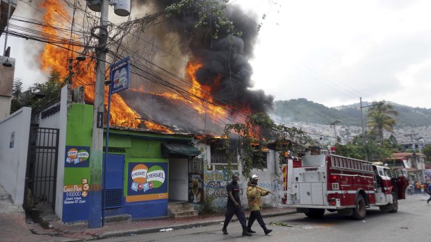The roof of a building burns after being set on fire by protesters in Port-au-Prince.