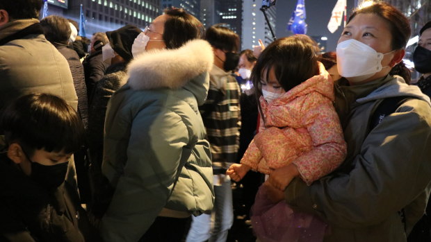 Shin Jeong-nam, 43, a housewife with her two children at Lee’s rally. 