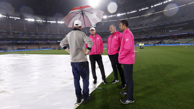 MCG curator Matt Page confers with umpires at the MCG during the washed out game between Australia and England.