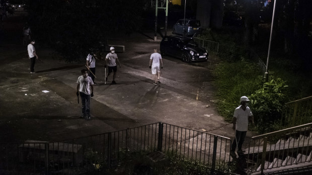 Men armed with sticks and poles outside a train station in Yuen Long, a Hong Kong border town, July 21.