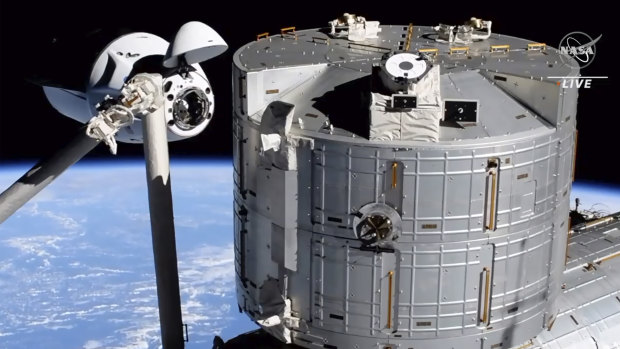 Elon Musk’s SpaceX Crew Dragon spacecraft, left, docking with the International Space Station.