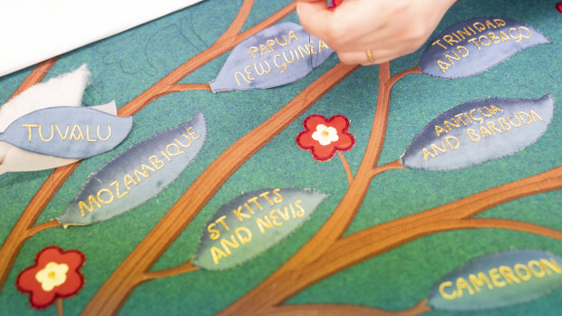 Embroiders work on part of the anointing screen during a visit by Charles and Camilla to the Royal College of Needlework at Hampton Court Palace, Surrey.