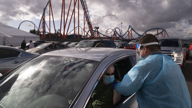 A nurse administers the COVID-19 vaccine at a mass vaccination site set up in the parking lot of Six Flags Magic Mountain in Valencia, California. 