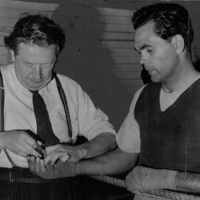 Trainer Tom Maguire adjusts Dave Sands' tapes before a workout at Newcastle prior to the Stadium bout with American Henry Brimm, August 3, 1950.
