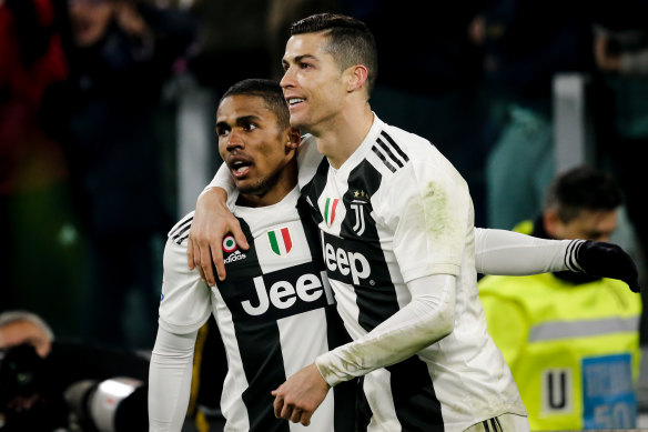 Douglas Costa celebrates with Cristiano Ronaldo during his time at Juventus.