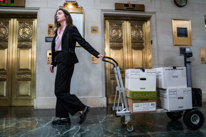 A co<em></em>ngressional staff member wheeling boxes of what were believed to be Trump’s tax returns to a House Ways and Means Committee meeting in 2022. 