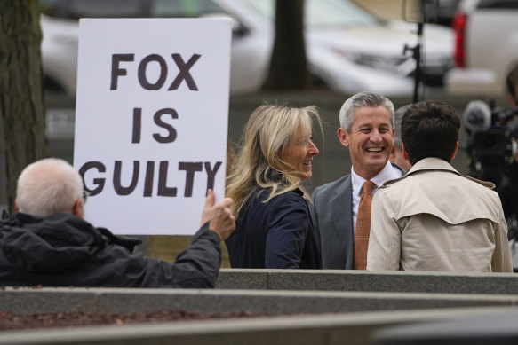 A protester holds a sign near representatives of Fox News outside the justice centre for the Dominion Voting Systems’ defamation lawsuit against Fox News in Wilmington.