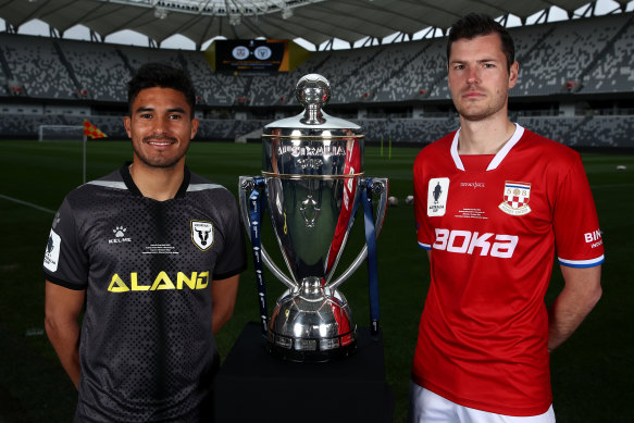 Macarthur FC captain Ulises Davila and his Sydney United 58 counterpart Adrian Vlastelica with Saturday night’s prize.