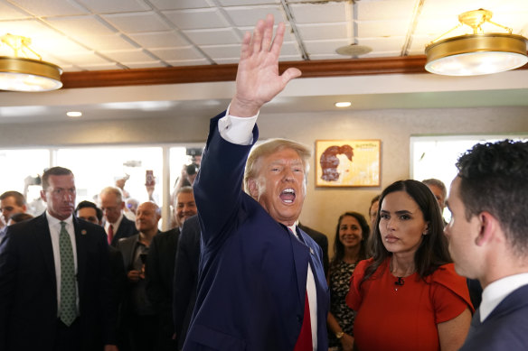 Donald Trump waves to supporters at Versailles restaurant.