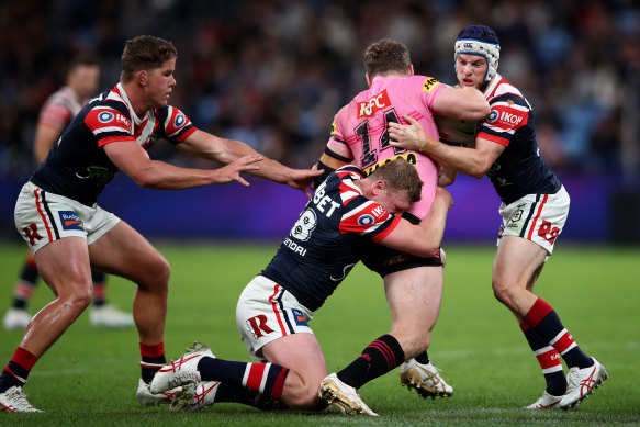 Liam Martin is tackled by Luke Keary and Drew Hutchison of the Roosters. 