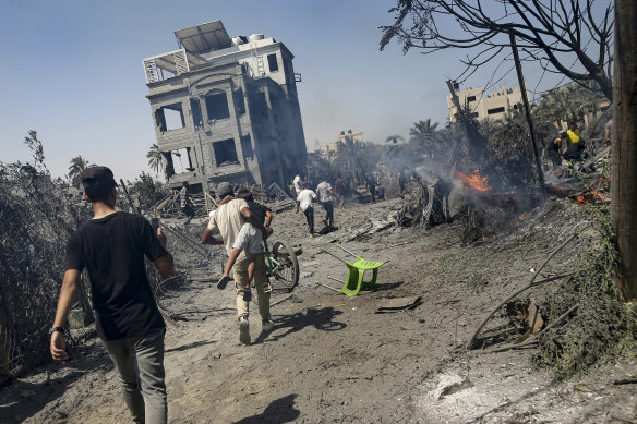 Palestinians evacuate from a site hit by an Israeli bombardment on Khan Younis, southern Gaza Strip on July 13.