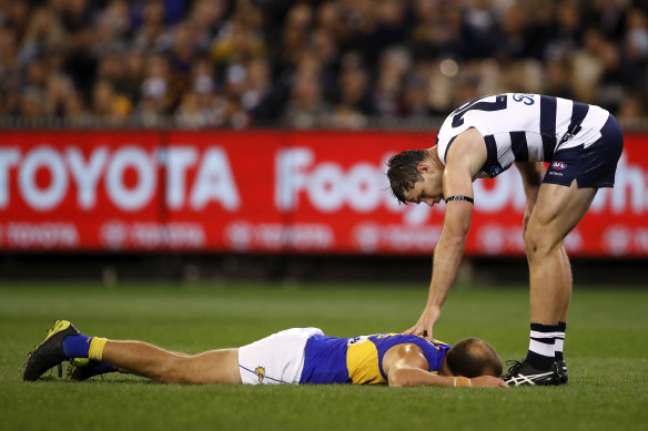 Tom Hawkins checks on Will Schofield after an incident off the ball.