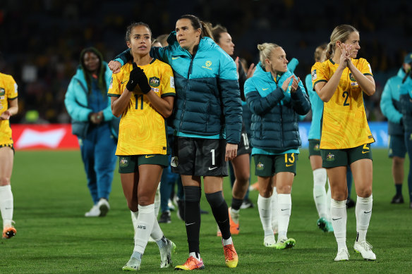 Mary Fowler of Australia is embraced by Lydia Williams as players of Australia applaud the fans after defeat to England.