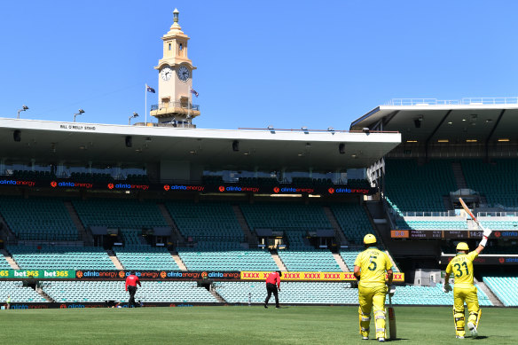 David Warner and Aaron Finch walk out to bat at an empty SCG. 