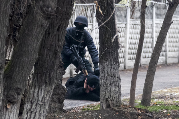 An armed riot police officer detains a protester in Almaty, Kazakhstan, on Saturday.