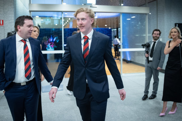 Clayton Oliver arrives with a Melbourne official.