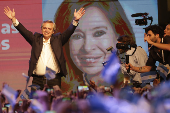 Peronist presidential candidate Alberto Fernandez waves to supporters in front of a large image of his running mate, former president Cristina Fernandez, after incumbent President Mauricio Macri conceded defeat.