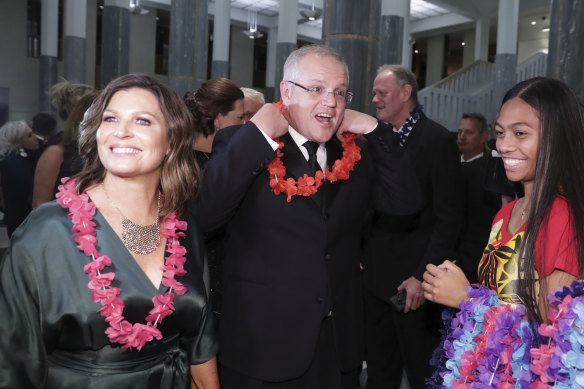 Prime Minister Scott Morrison and wife Jenny don garlands as they arrive at the Midwinter Ball.