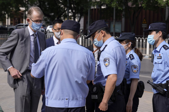 Australian ambassador to China Graham Fletcher, left, has his documents checked by policemen outside the No. 2 Intermediate People’s Court. he was denied access to Yang Hengjun’s case hearing.