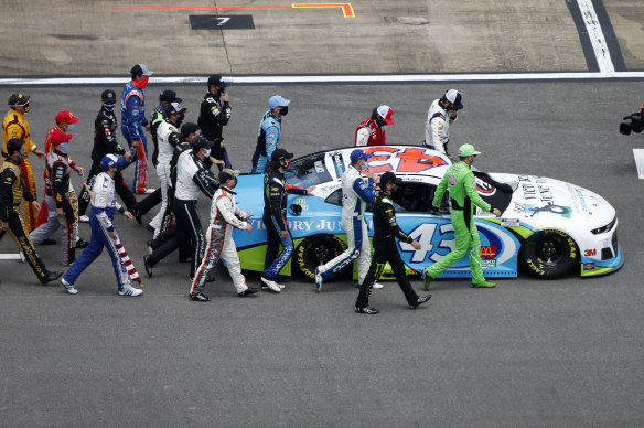 NASCAR drivers push Bubba Wallace's No.43 car to the front of the grid.