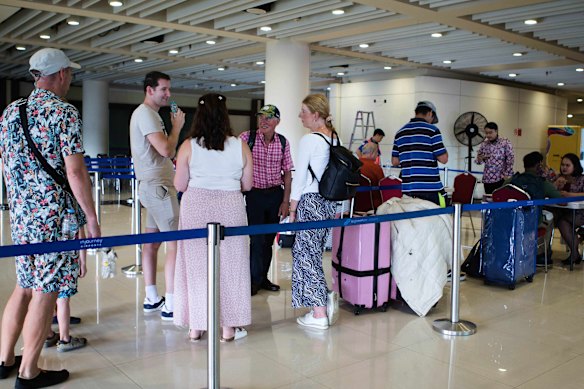 Stranded travelers queue up at an information desk as flights to the Middle East are cancelled following the attack on Iran by the US and Israel.