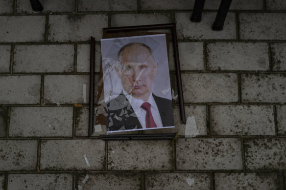 A smashed portrait of Russian President Vladimir Putin lies outside a police prison used to hold and torture Ukrainian prisoners by Russian forces in Kherson.