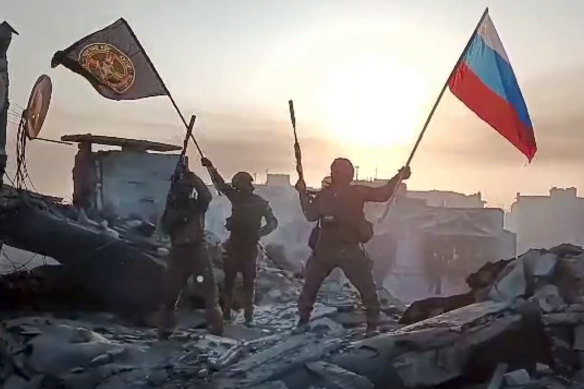 Wagner Group mercenaries wave flags in Bakhmut, Ukraine.