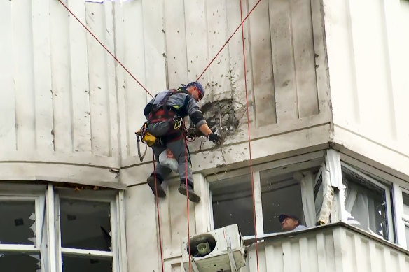 Investigators inspect the building after a Ukrainian drone damaged an apartment building in Moscow, Russia.