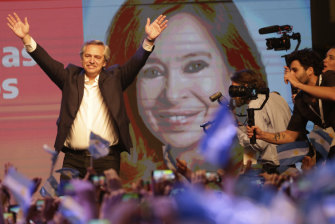 Peronist presidential candidate Alberto Fernandez waves to supporters in front of a large image of his running mate, former president Cristina Fernandez, after incumbent President Mauricio Macri conceded defeat.