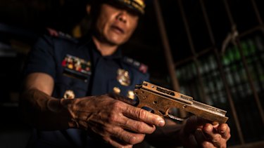Col. Jaime Quiocho holds a confiscated gun part made by illegal gunsmiths in Danao.