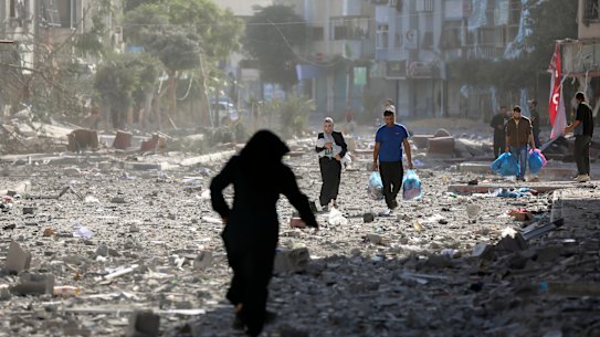 Palestinians leave their homes following Israeli bombardment on Gaza City on Monday.