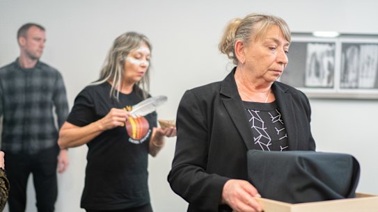 Wendy Dalitz, the assistant director of Indigenous Repatriation for the Australian government, carries the remains of First Nations ancestors during the ceremony.