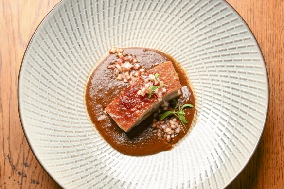 Lechon, a hunk of Western Plains pork, is served with a deep brown, beautifully spiced peanut mole.