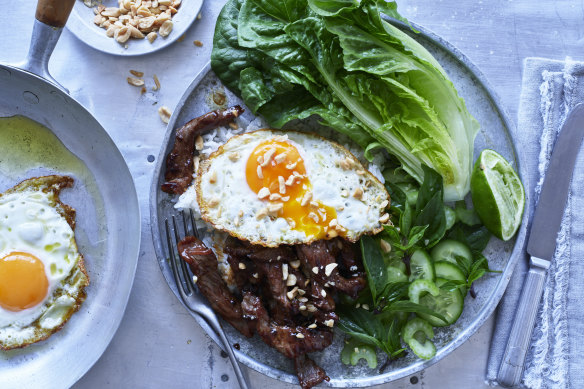 Beef stir-fry with fried egg and peanuts.