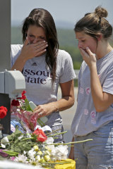 Rina Bernard, left, and Keri Johnson leave flowers on a car believed to belong to a victim of the duck boat accident.