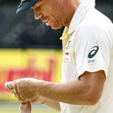 David Warner applies a bandage to his injured hand on the third day of the second Test in Port Elizabeth.