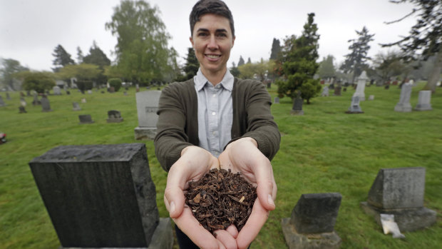 Katrina Spade, the founder and chief executive of Recompose, displays a sample of the compost material left from the decomposition of a cow, using a combination of wood chips, alfalfa and straw, as she poses in a cemetery in Seattle. 