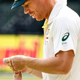 David Warner applies a bandage to his injured hand on the third day of the second Test in Port Elizabeth.